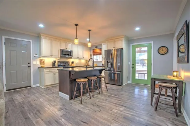 a kitchen with a table chairs refrigerator and cabinets