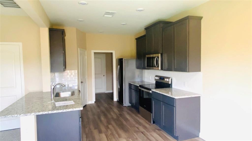 261 Moonstone Way Princeton, TX 75407 - Photo 3 of 9 a kitchen with granite countertop stainless steel appliances a sink and counter space