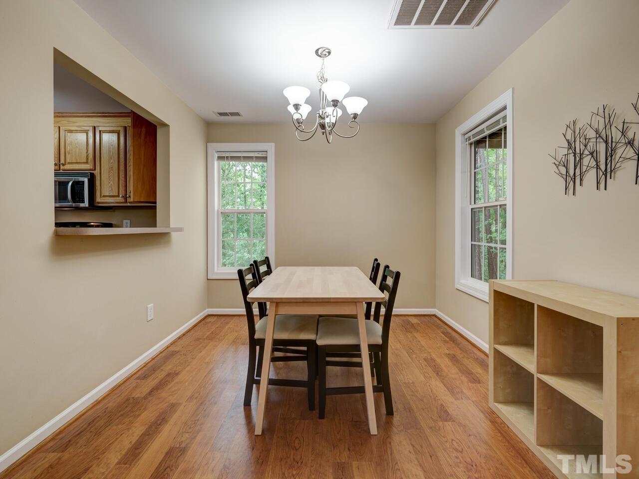 2221 Mountain Mist Court, Unit 101 Raleigh, NC 27603 - Photo 11 of 31 a view of a dining room with furniture a chandelier and wooden floor