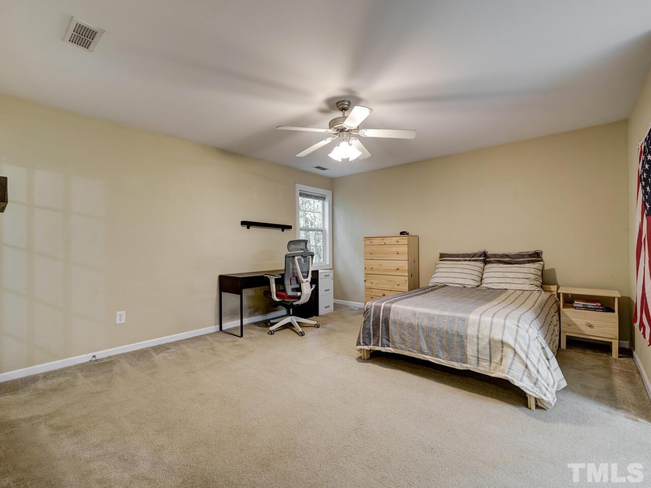 2221 Mountain Mist Court, Unit 101 Raleigh, NC 27603 - Photo 18 of 31 a bedroom with a bed and a ceiling fan