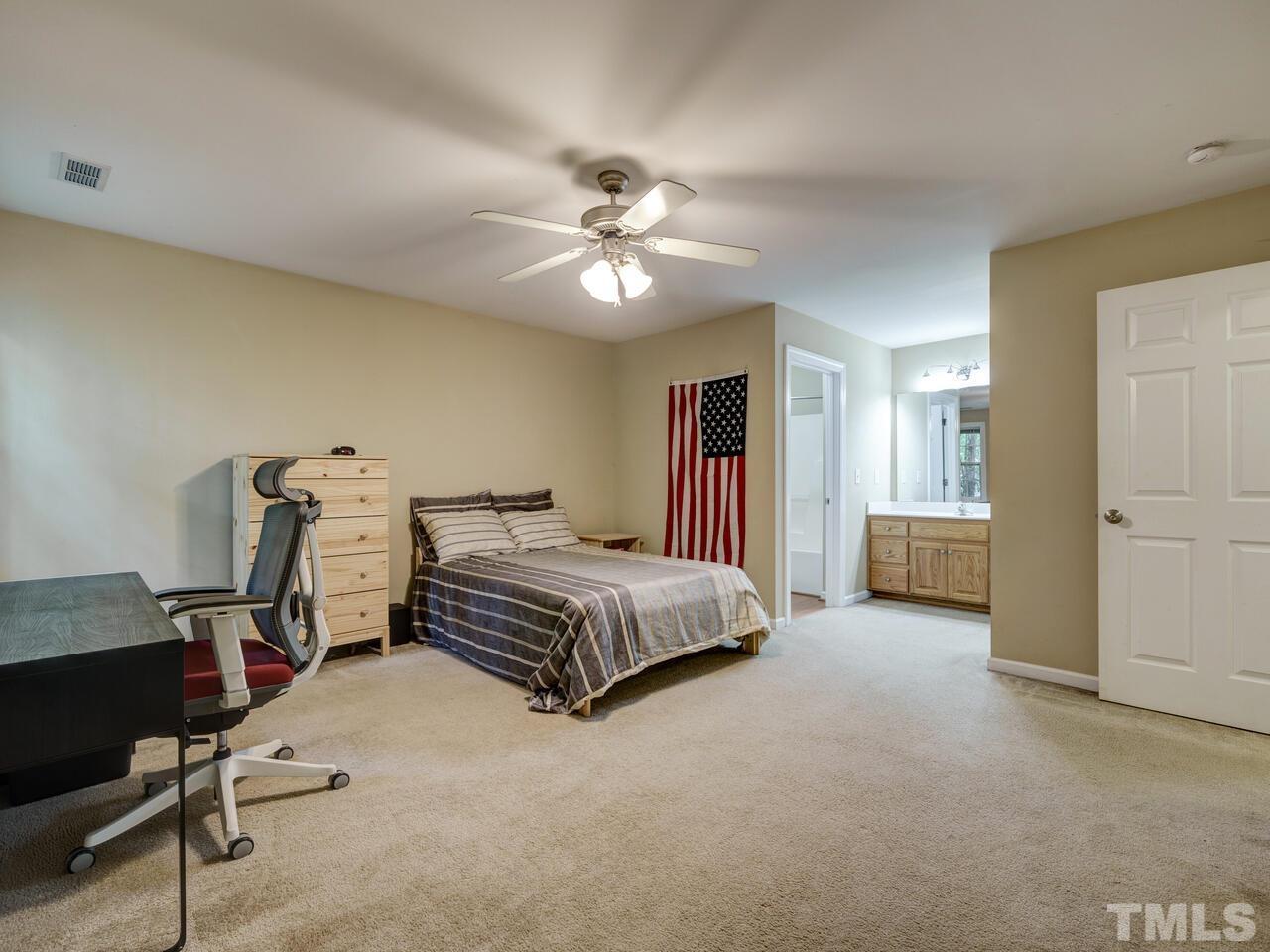 2221 Mountain Mist Court, Unit 101 Raleigh, NC 27603 - Photo 20 of 31 a spacious bedroom with a bed and a chandelier