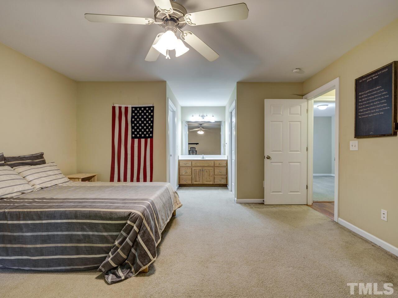 2221 Mountain Mist Court, Unit 101 Raleigh, NC 27603 - Photo 21 of 31 a bedroom with a bed and a chandelier