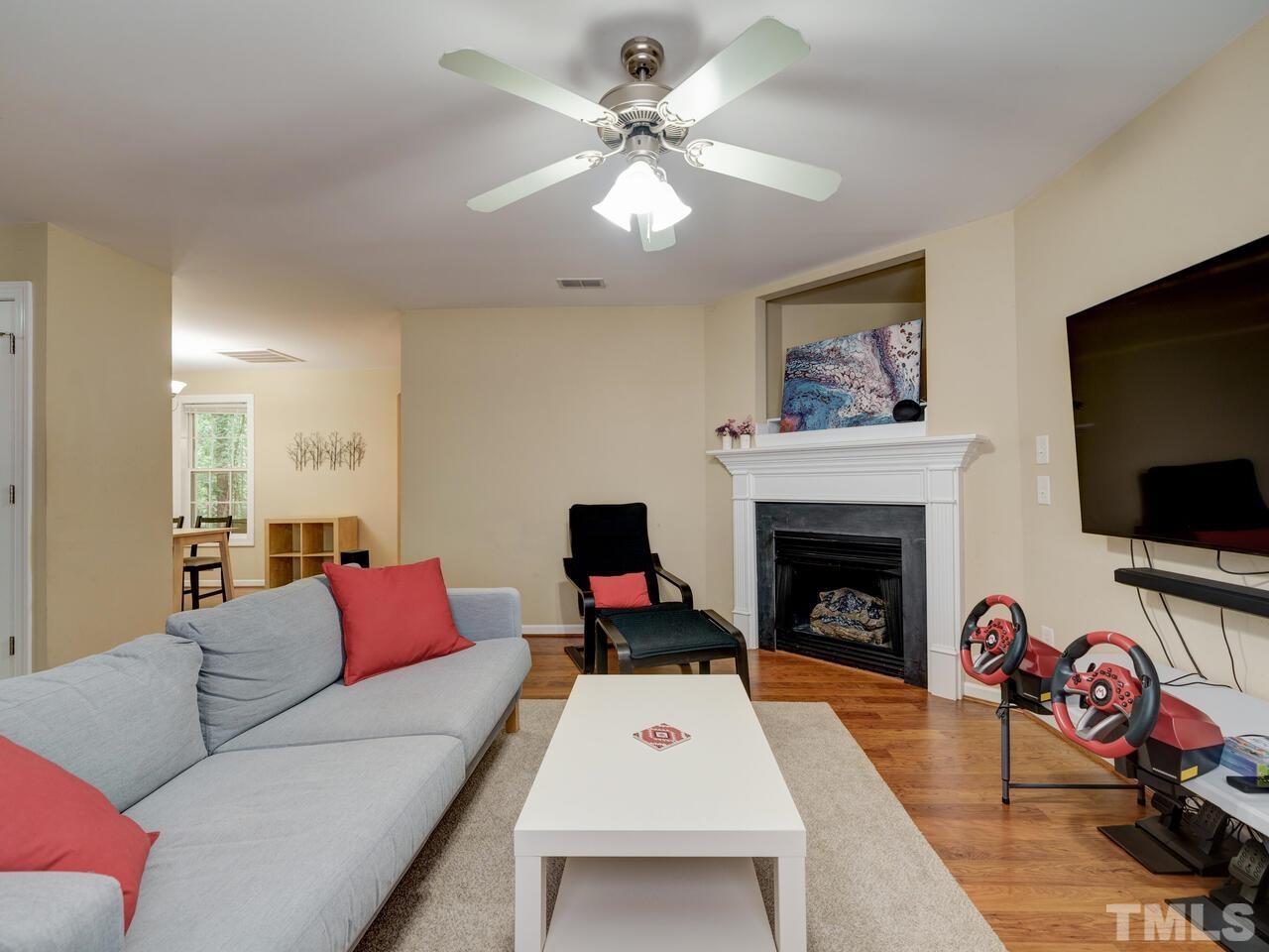 2221 Mountain Mist Court, Unit 101 Raleigh, NC 27603 - Photo 5 of 31 a living room with furniture a flat screen tv and a fireplace