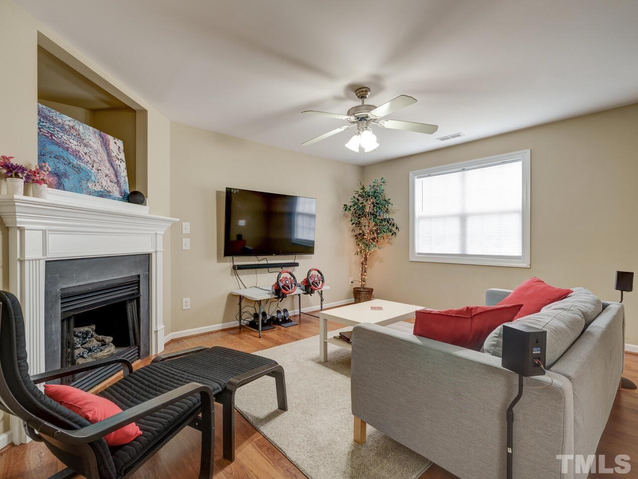 2221 Mountain Mist Court, Unit 101 Raleigh, NC 27603 - Photo 6 of 31 a living room with furniture a flat screen tv and a fireplace