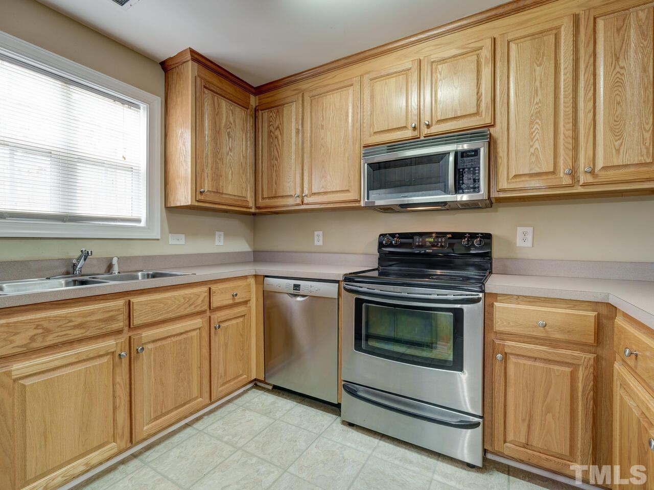 2221 Mountain Mist Court, Unit 101 Raleigh, NC 27603 - Photo 7 of 31 a kitchen with cabinets appliances and a window