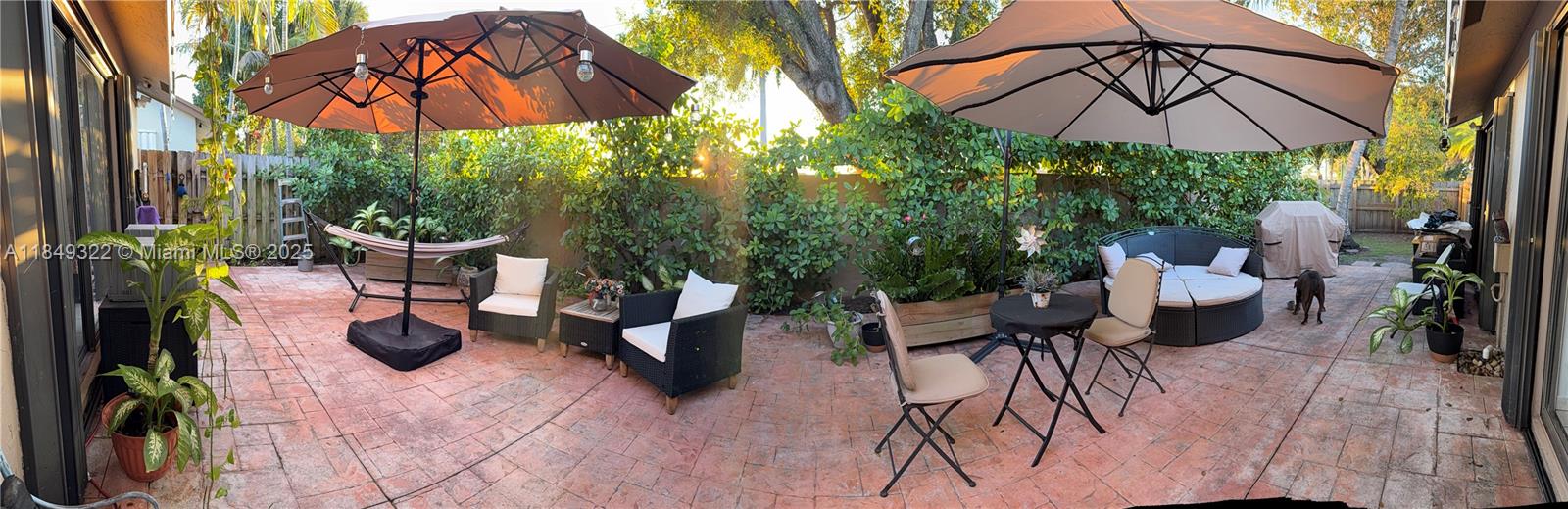 13402 Southwest 116th Place Miami, FL 33176 - Photo 13 of 16 a view of a patio with couches table and chairs under an umbrella