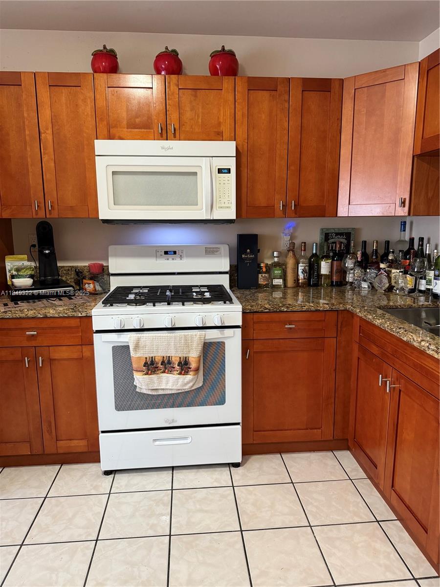 13402 Southwest 116th Place Miami, FL 33176 - Photo 16 of 16 a kitchen with stainless steel appliances granite countertop a stove a sink and a microwave