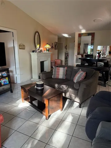 a living room with furniture a flat screen tv and a mirror
