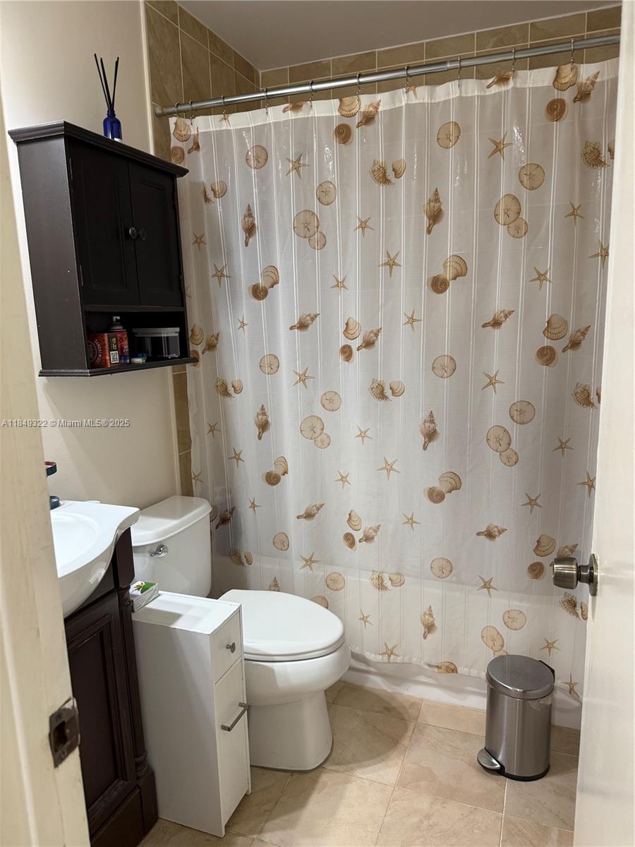13402 Southwest 116th Place Miami, FL 33176 - Photo 7 of 16 a bathroom with a toilet and a shower curtain