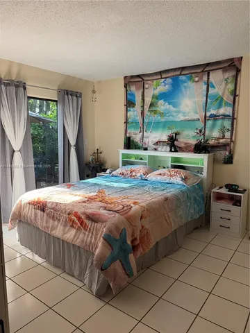 a bedroom with a bed and large windows