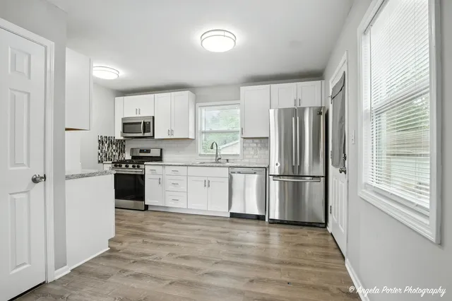 a kitchen with stainless steel appliances granite countertop a refrigerator and a stove top oven