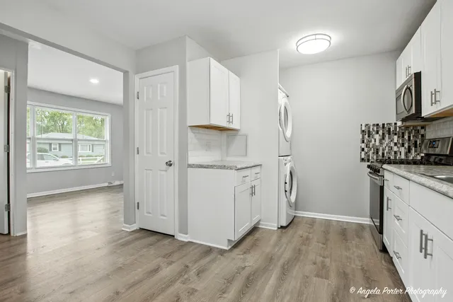 a kitchen with granite countertop white cabinets and sink