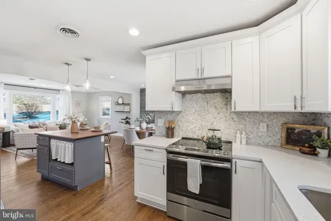 a kitchen with granite countertop a sink cabinets and stainless steel appliances