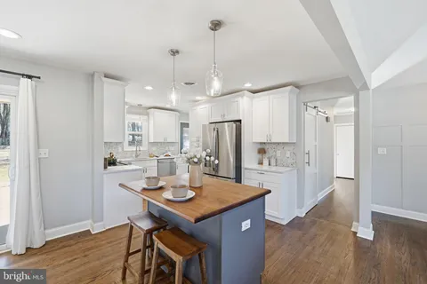 a kitchen with a refrigerator a sink and a dining table