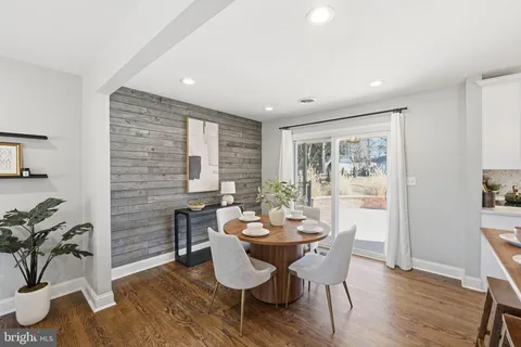 a dining room with furniture potted plants and wooden floor