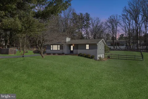 a front view of house with a garden and trees