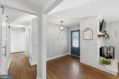 a view of a hallway with wooden floor and furniture