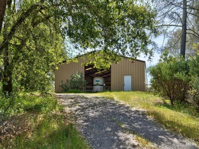 a view of a house with a backyard and trees