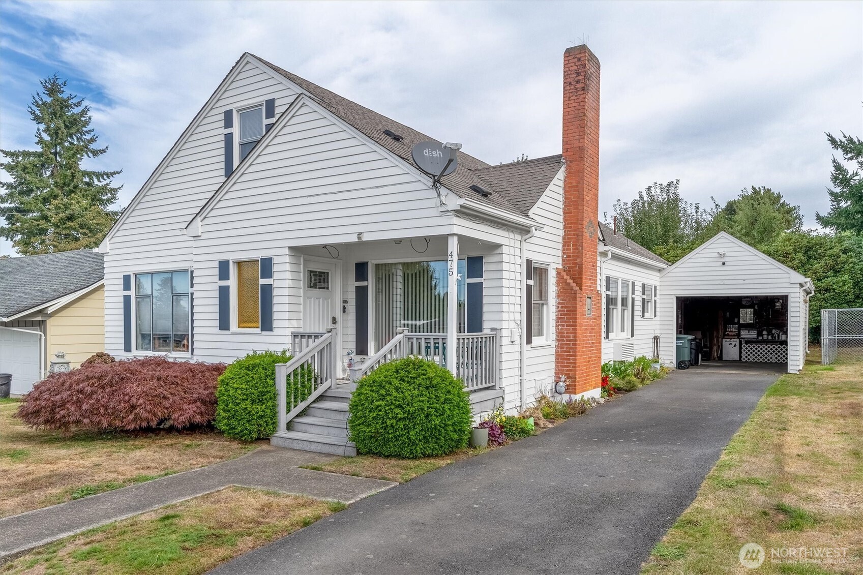 a front view of a house with a garden and plants