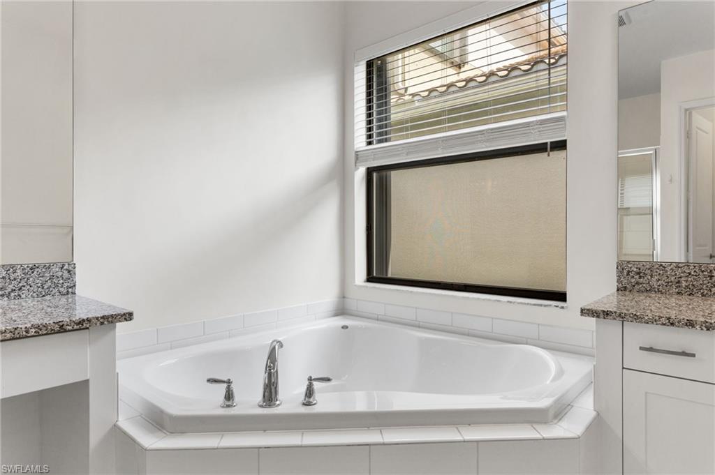 4486 Crimson Avenue Naples, FL 34119 - Photo 14 of 22 a white bath tub sitting next to a window