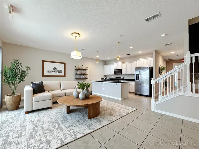 a view of kitchen with kitchen island granite countertop white cabinets and stainless steel appliances