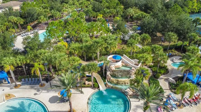a view of a tennis ground with large trees