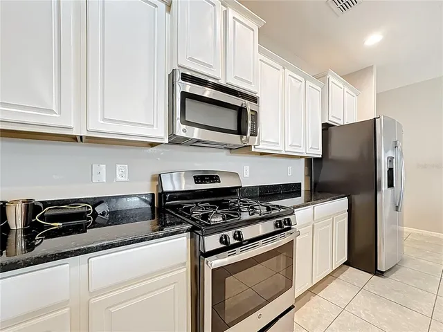 a kitchen with stainless steel appliances a sink a stove a microwave and cabinets