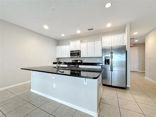 a kitchen with granite countertop a sink and cabinets