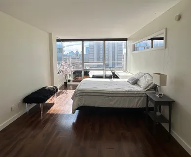 a bedroom with a bed and a large window