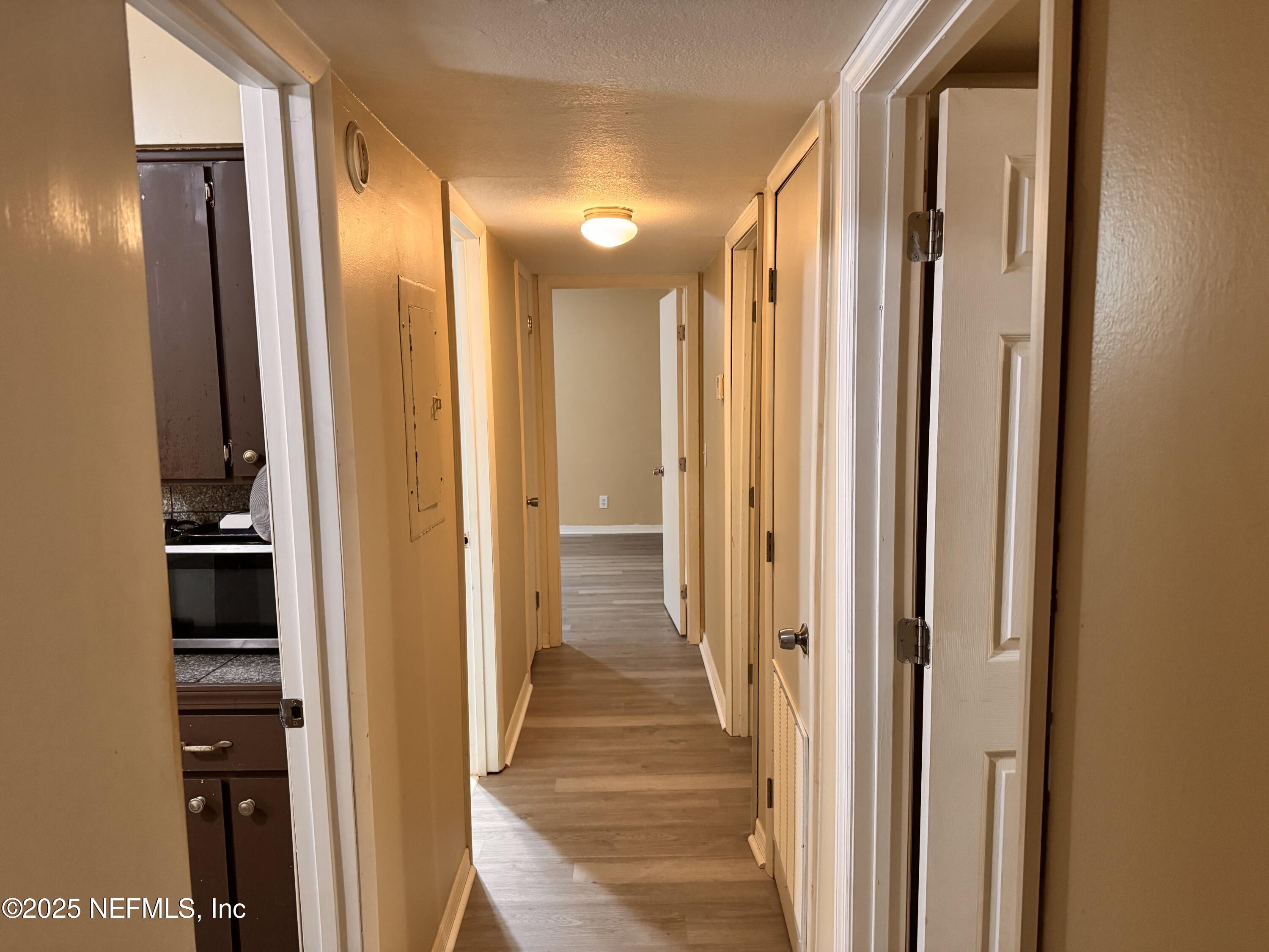 1707 El Prado Road, Unit 3 Jacksonville, FL 32216 - Photo 8 of 24 a view of a hallway with wooden floor and windows in a bathroom