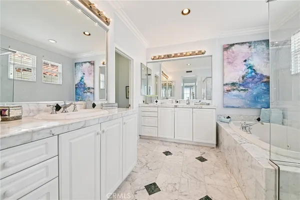 a spacious bathroom with a double vanity sink mirror and bathtub