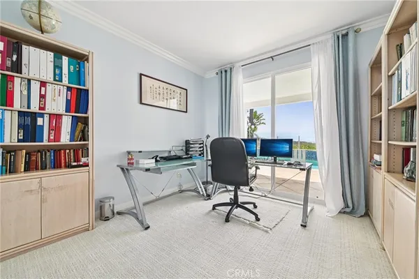 a view of a workspace with a bookshelf and a workspace