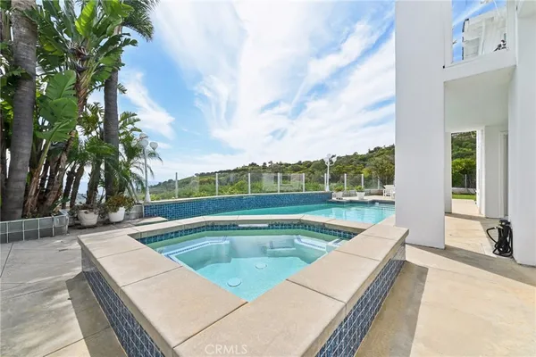swimming pool with outdoor seating and tub