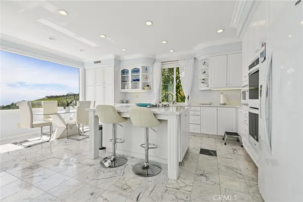 a living room with furniture a dining table and white chairs