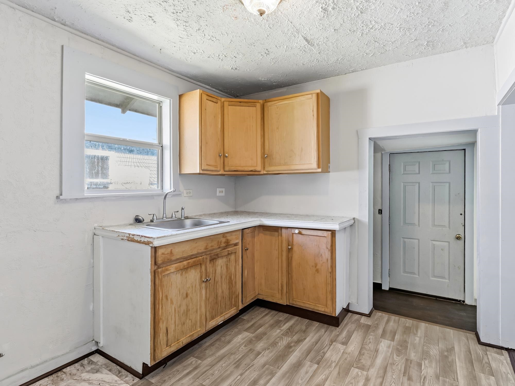 737 9th Street Port Arthur, TX 77640 - Photo 11 of 20 a kitchen with a sink a window and cabinets
