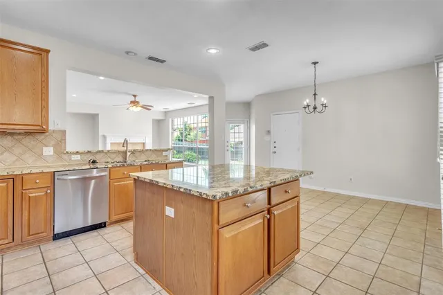 a kitchen with granite countertop a sink cabinets and stainless steel appliances