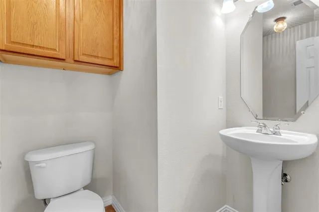 a bathroom with a toilet sink and mirror