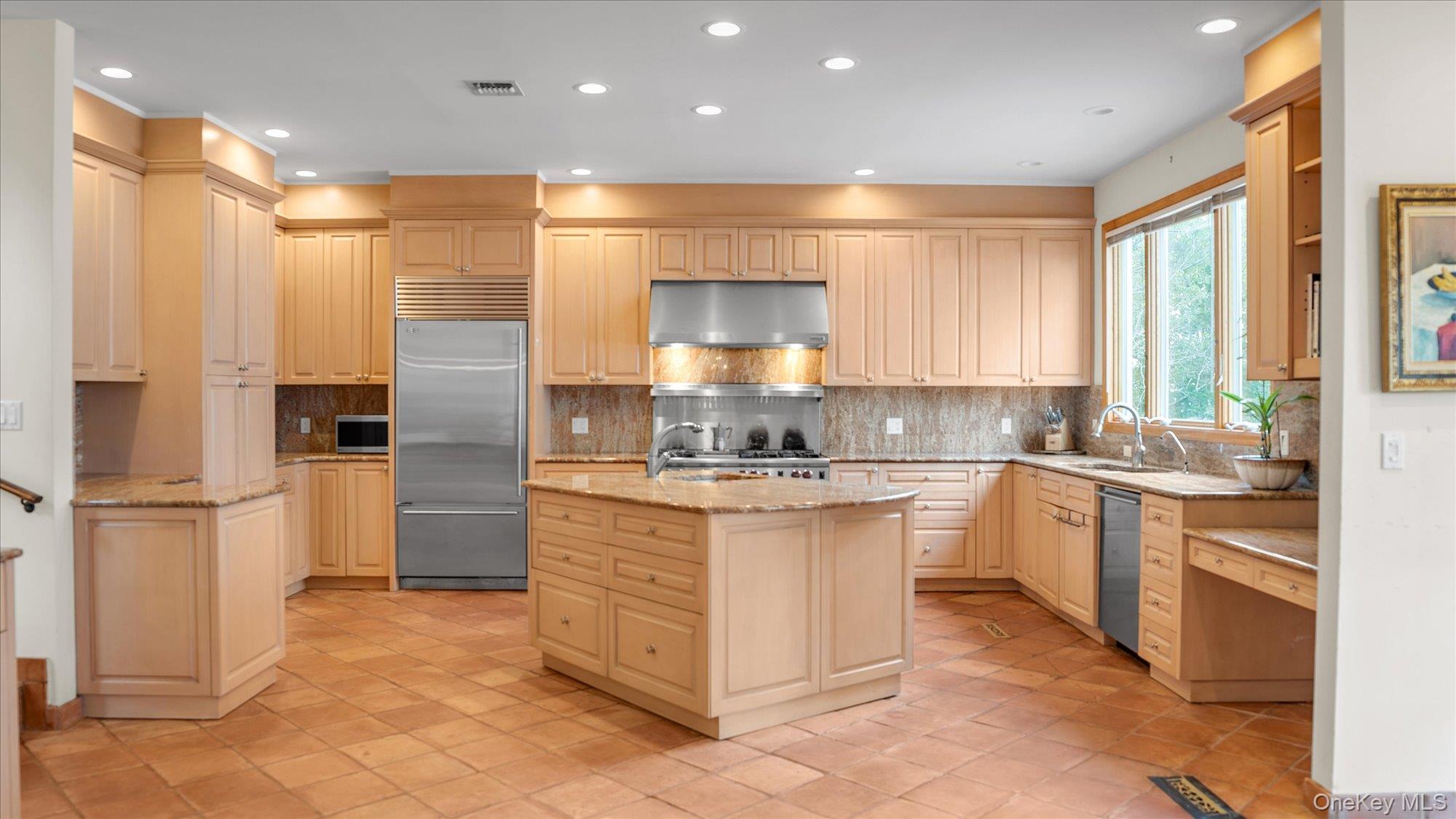 3400 Dignans Road Cutchogue, NY 11935 - Photo 15 of 50 Kitchen with tasteful backsplash, light stone counters, recessed lighting, appliances with stainless steel finishes, and an island with sink
