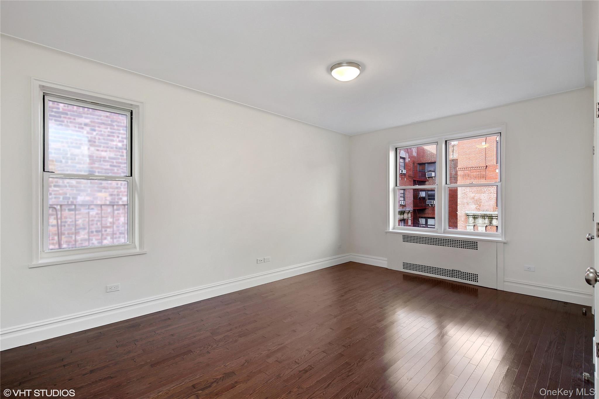 73-12 35th Avenue, Unit D2 Queens, NY 11372 - Photo 4 of 15 a view of an empty room with wooden floor and a window