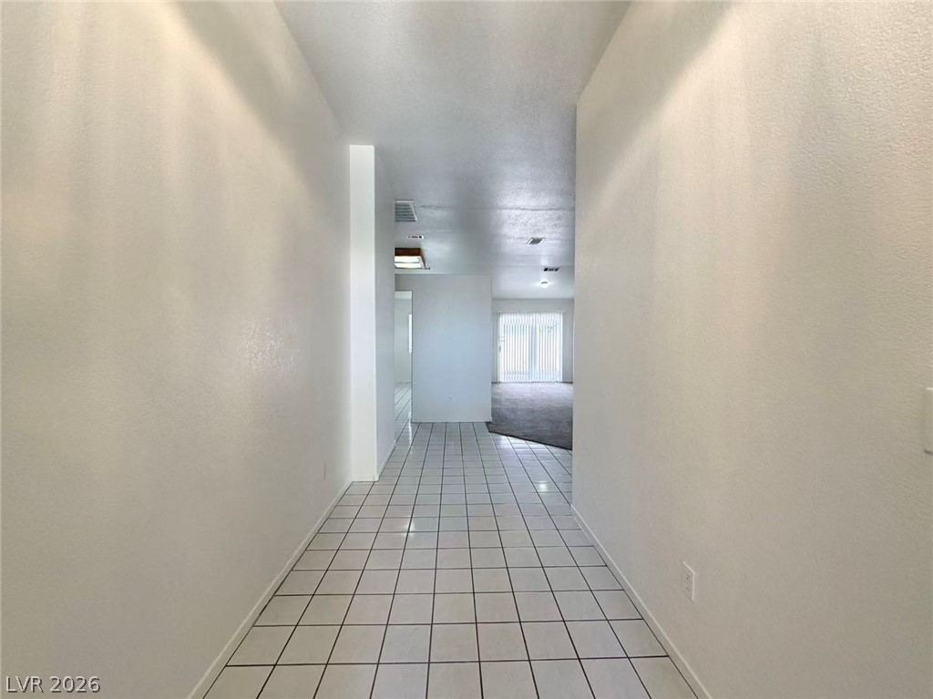 8620 Magnolia Ridge Avenue Las Vegas, NV 89134 - Photo 6 of 15 A lengthy, well-lit entry hall with crisp white walls leads to a spacious, naturally illuminated living area.