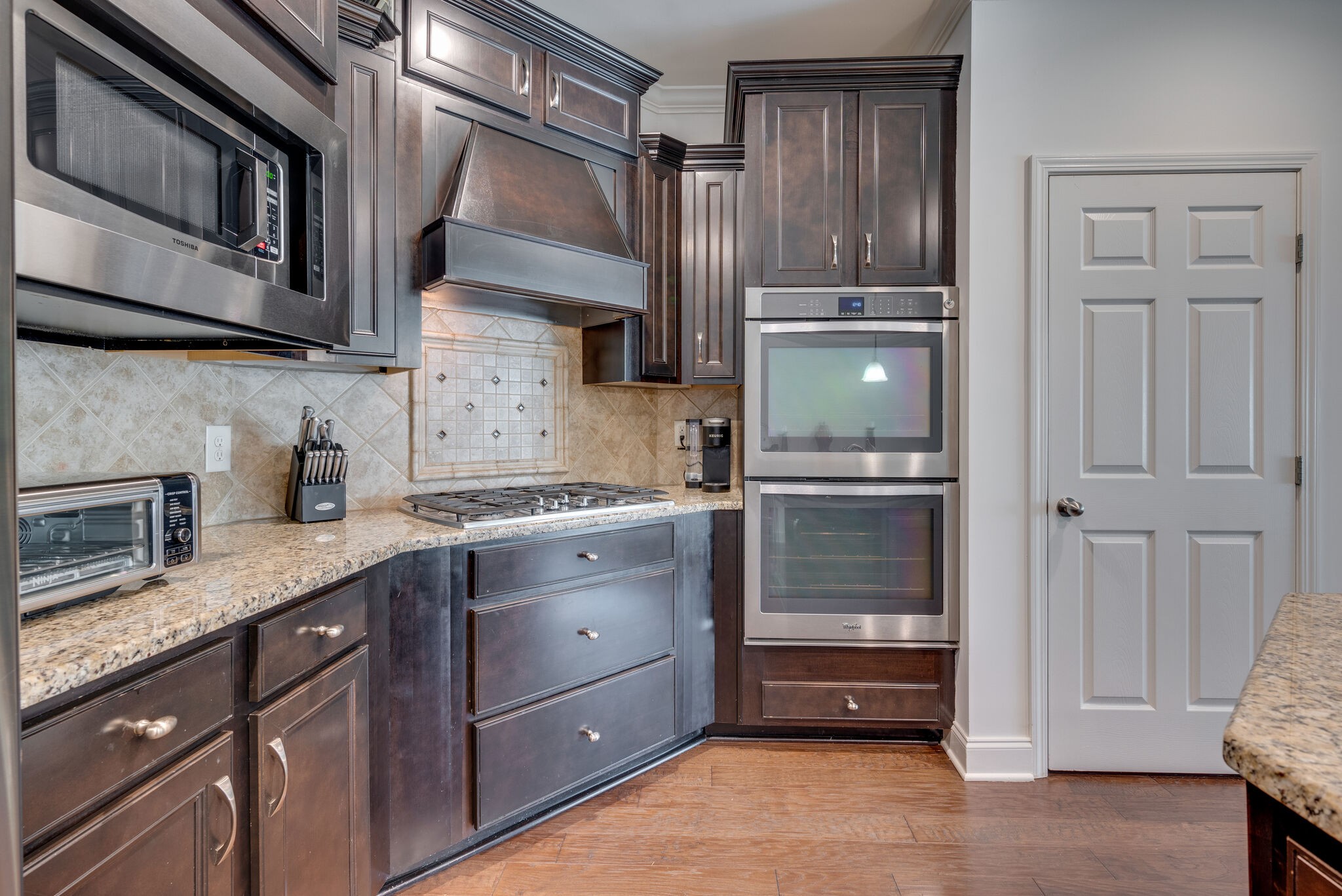 5012 Rizer Point Drive Franklin, TN 37069 - Photo 6 of 38 a kitchen with granite countertop cabinets and stainless steel appliances