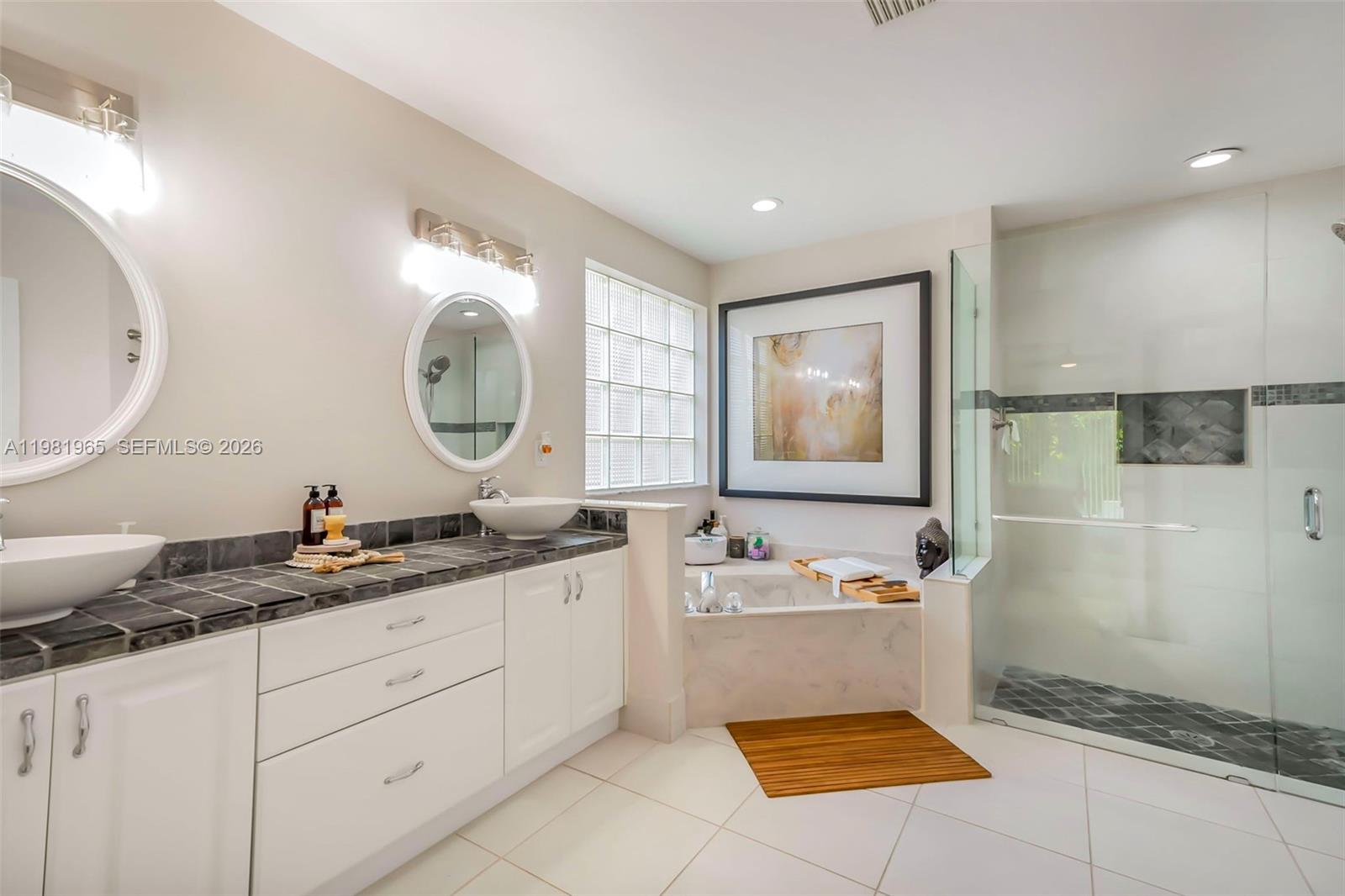 11030 Harbour Springs Circle Boca Raton, FL 33428 - Photo 13 of 39 a bathroom with a sink a mirror and a bathtub