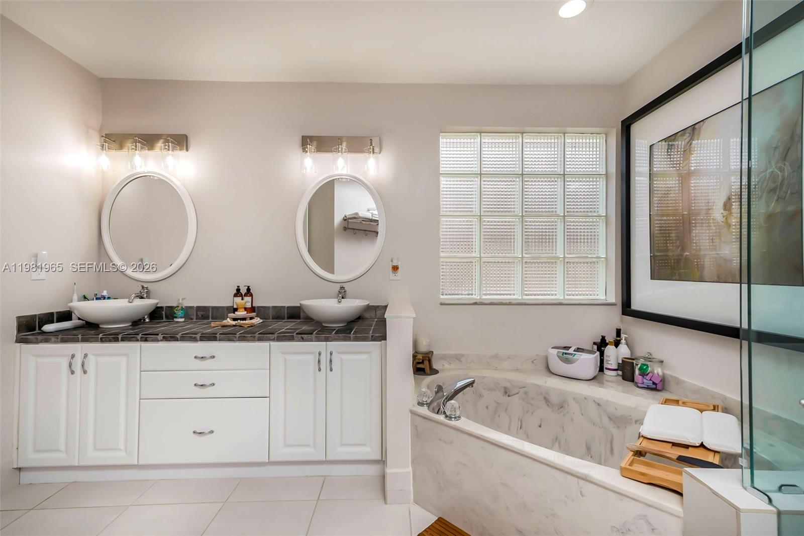 11030 Harbour Springs Circle Boca Raton, FL 33428 - Photo 14 of 39 a bathroom with a granite countertop sink a mirror a vanity and a bathtub