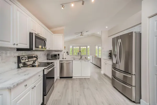 a kitchen with white cabinets and stainless steel appliances