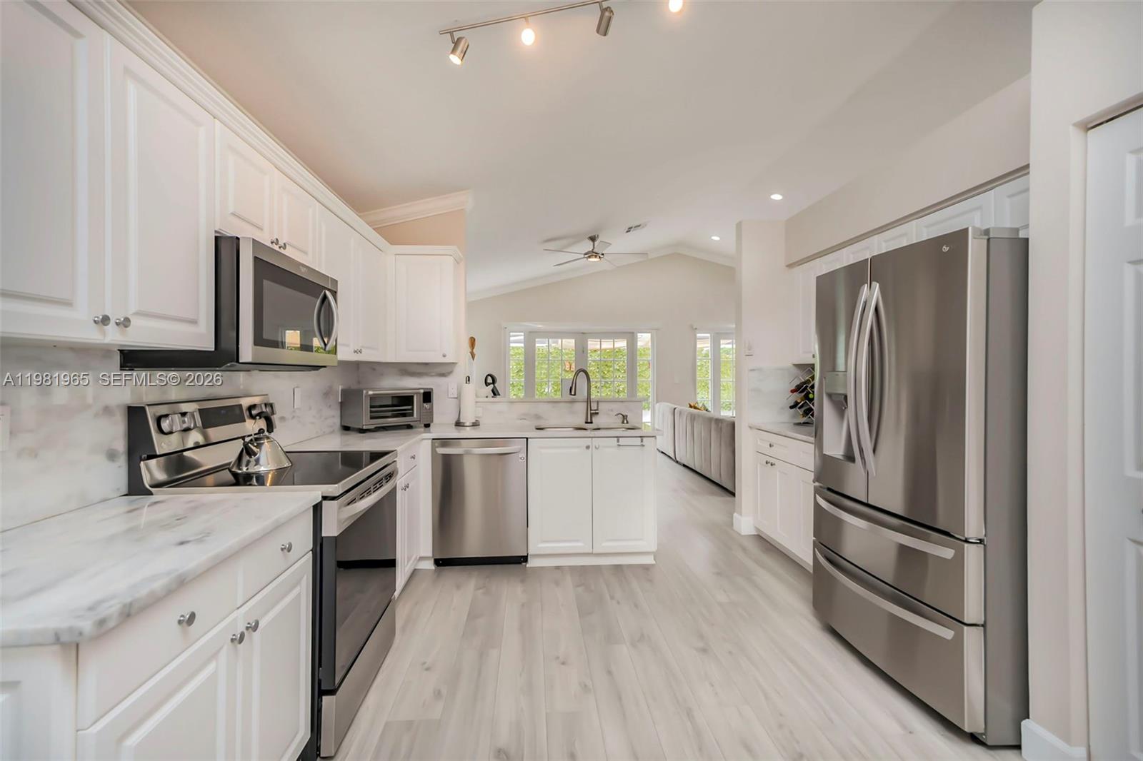 11030 Harbour Springs Circle Boca Raton, FL 33428 - Photo 3 of 39 a kitchen with white cabinets and stainless steel appliances