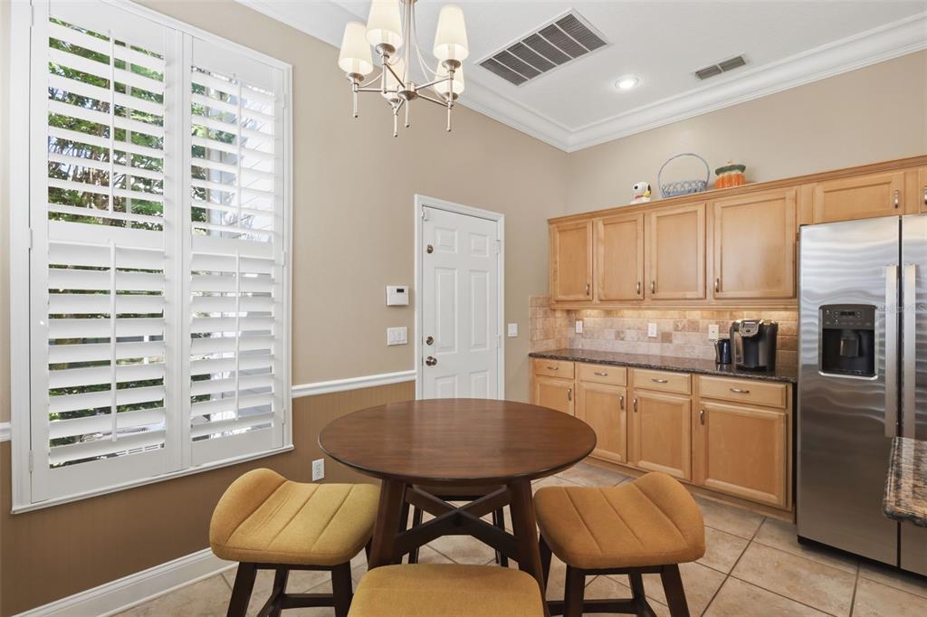 907 Pawstand Road Celebration, FL 34747 - Photo 21 of 49 a kitchen with a table chairs sink and cabinets