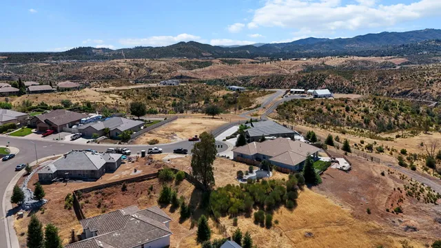 an aerial view of residential houses with outdoor space and mountain view