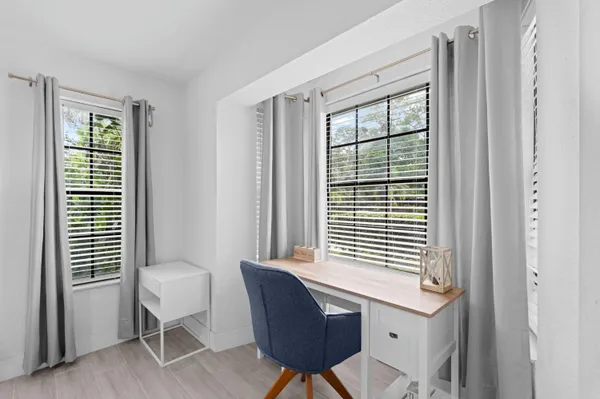 a view of a workspace with a window and chair