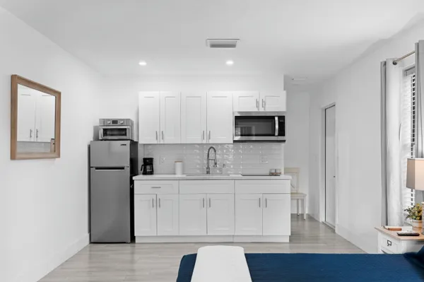 a kitchen with a sink a microwave a refrigerator and cabinets