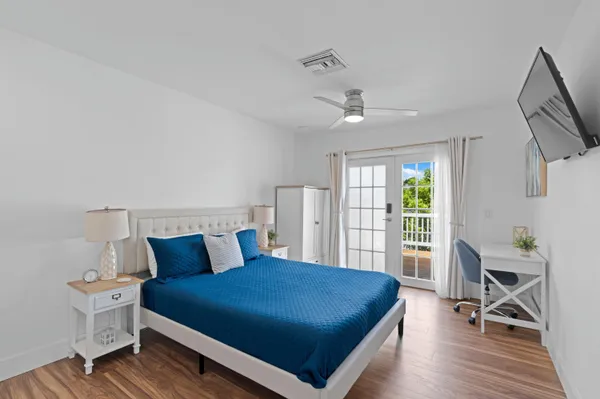 a bedroom with a bed a table and a large window